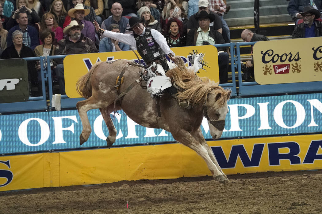 Chase Brooks of Deer Lodge, Mont. (111) competes in the saddle bronc riding event during the ei ...