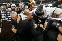 Oakland Raiders head coach Jon Gruden, bottom, hugs fans after an NFL football game against the ...