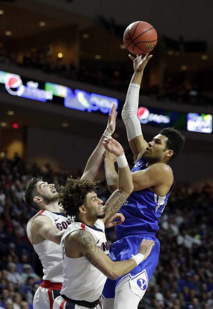 BYU's Yoeli Childs shoots over Gonzaga's Killian Tillie, left, and Josh Perkins during the firs ...