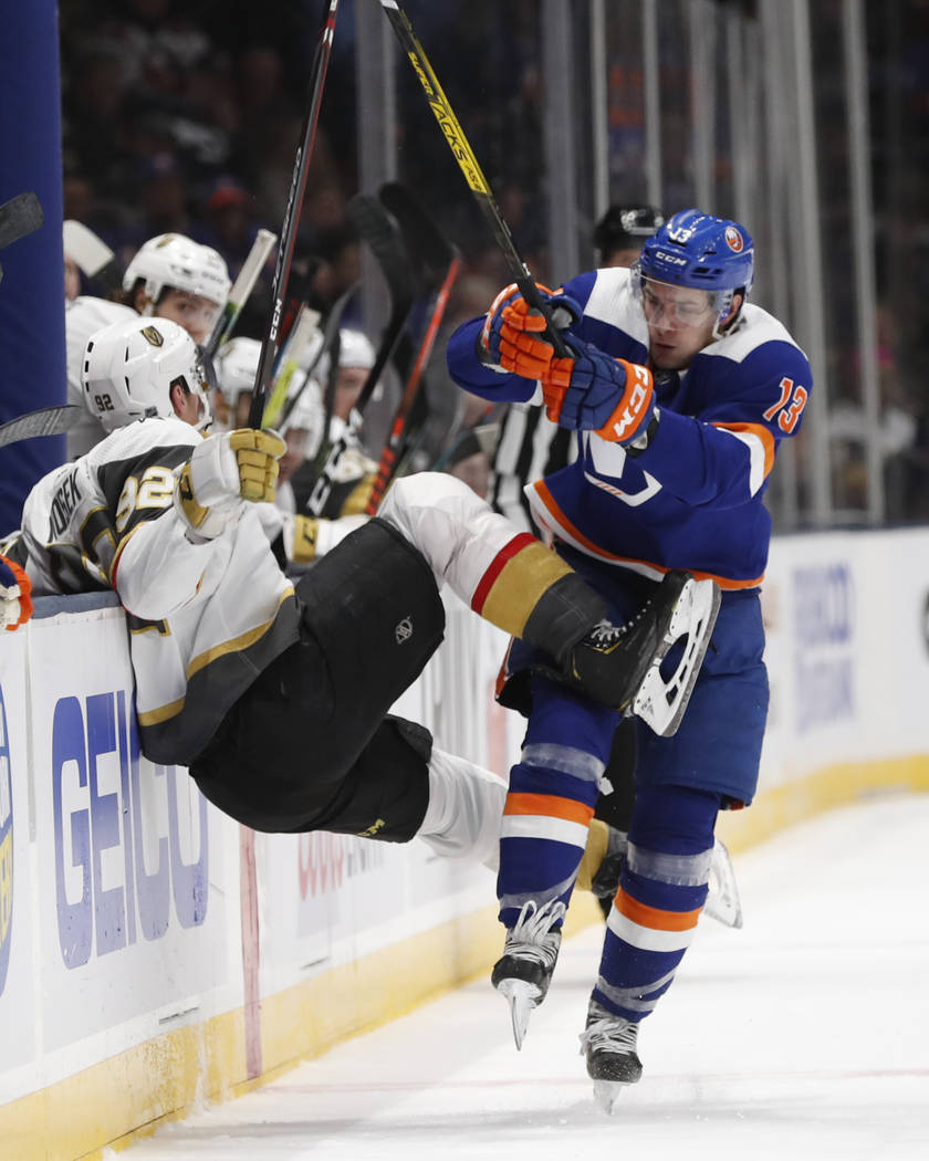 New York Islanders center Mathew Barzal (13) collides with Vegas Golden Knights left wing Tomas ...