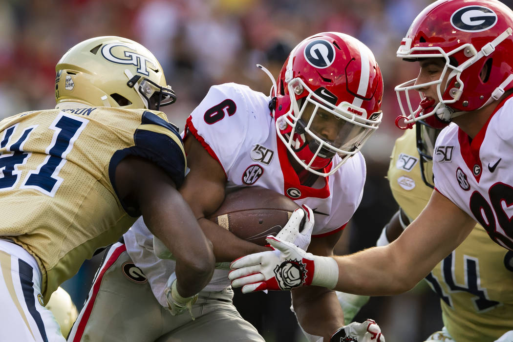 Georgia running back Kenny McIntosh runs with Georgia Tech defensive lineman Jaquan Henderson ( ...