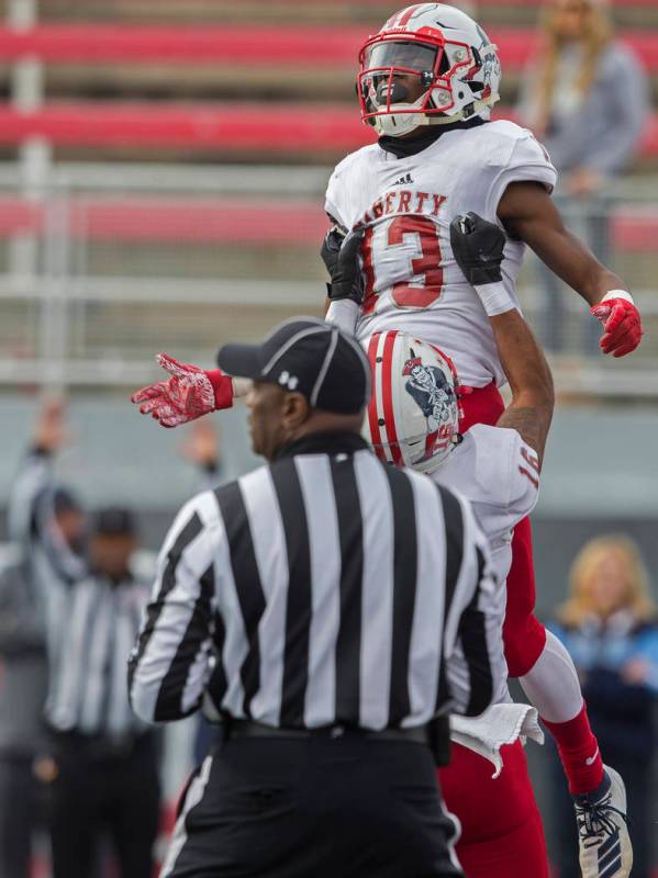 Liberty junior wide receiver Corey Hebert (13) celebrates with Liberty senior wide receiver Mau ...