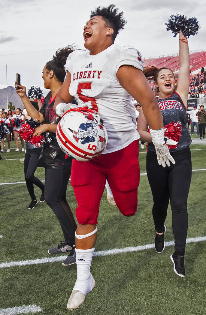 Liberty junior running back Ezra Tomhoon (5) celebrates after defeating Centennial 50-7 to win ...