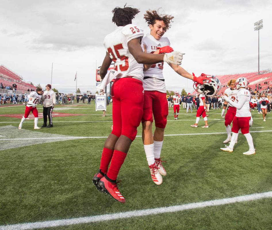 Liberty's Dominick Payne (25) celebrates with teammate Logann Britt (83) after defeating Centen ...