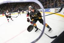 Golden Knights' Reilly Smith (19) and Arizona Coyotes' Jakob Chychrun (6) watch the puck fly to ...