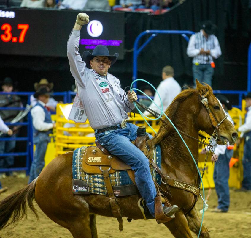 Heeler Cole Davison of Stephenville, Texas, celebrates a winning time in Team Roping with heade ...