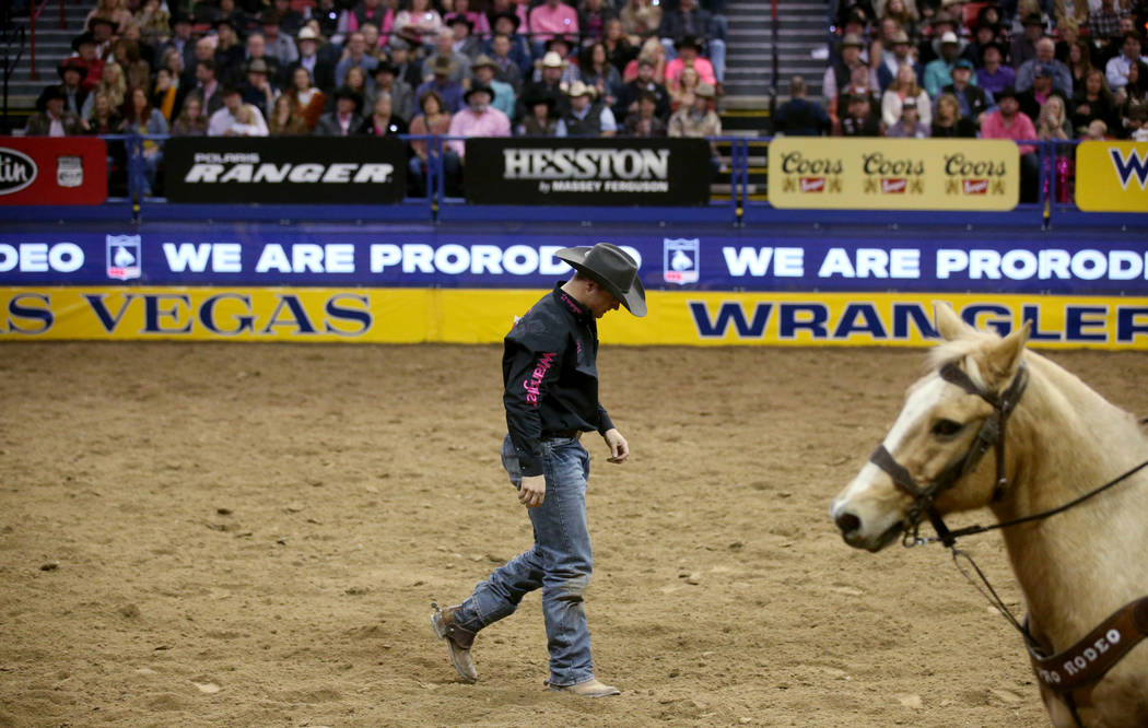 J.D. Struxness of Milan, Minn. walks off the dirt after failing to catch his steer in the Steer ...