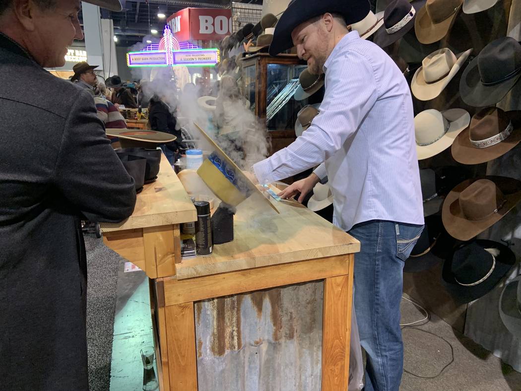 Custom hat maker Braydan Shaw plies his trade as customer Mitch Clum looks on Saturday at the B ...