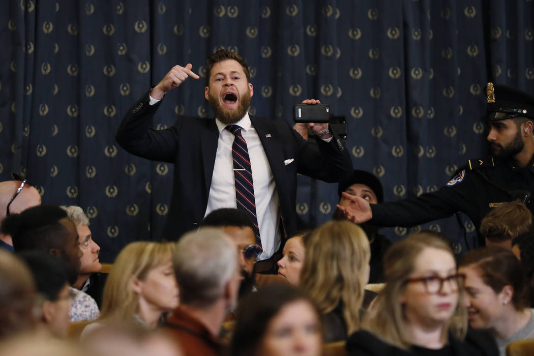 A protestor speaks out as the House Judiciary Committee hears investigative findings in the imp ...