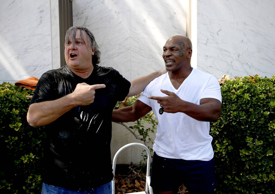 Mike Tyson laughs moments after dumping ice water on Las Vegas attorney David Chesnoff, left, o ...