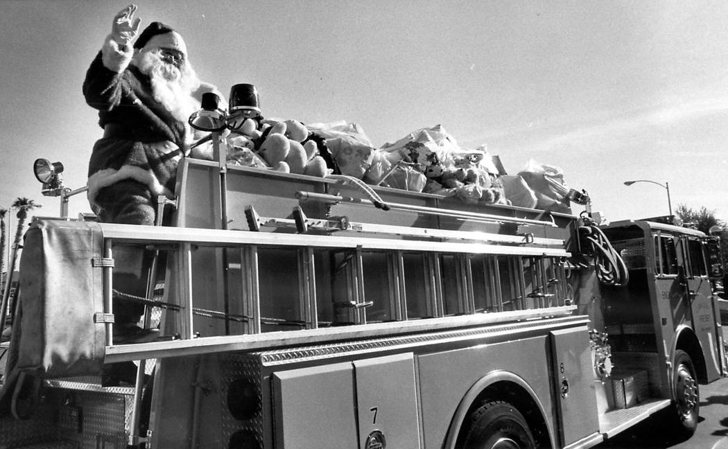 Santa Claus arrives at Child Haven on a gift-packed fire engine on Christmas Eve 1985. Gary Tho ...