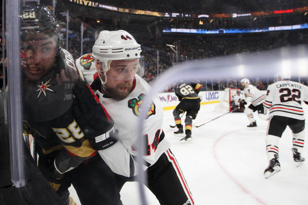 Vegas Golden Knights left wing William Carrier (28) is slammed against the glass by Chicago Bla ...