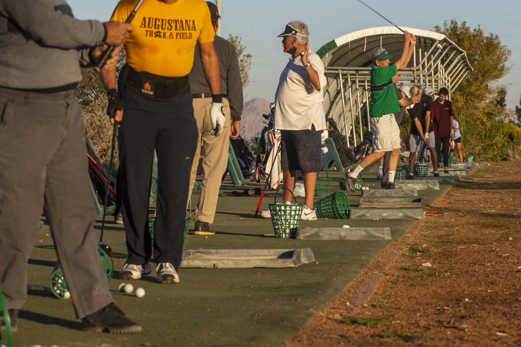 Golfers practice on the driving range near the clubhouse on the Palm Course at the Angel Park G ...