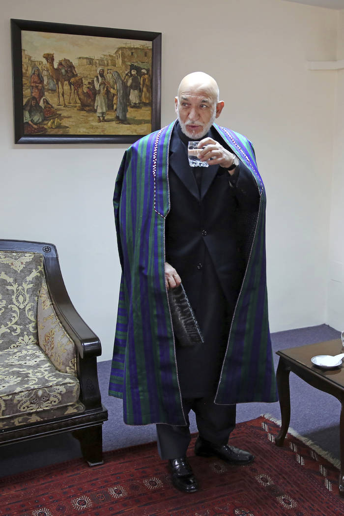 Former Afghan President Hamid Karzai drinks a glass of water after an interview with The Associ ...