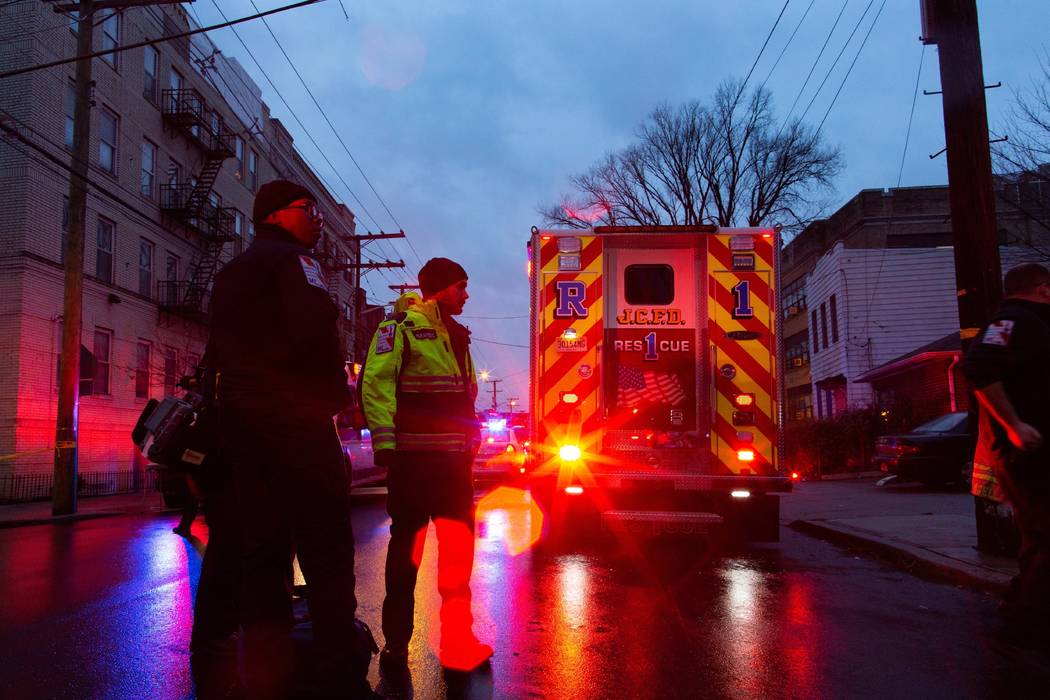 First responders and law enforcement personnel stand near the scene following a shooting, Tuesd ...