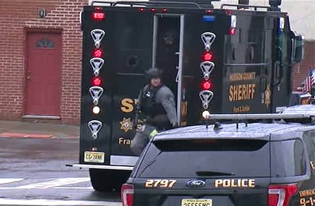 In an image taken from video, Hudson County Swat team officers arrive at the scene following re ...
