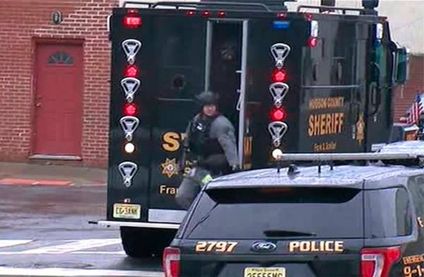 In an image taken from video, Hudson County Swat team officers arrive at the scene following re ...
