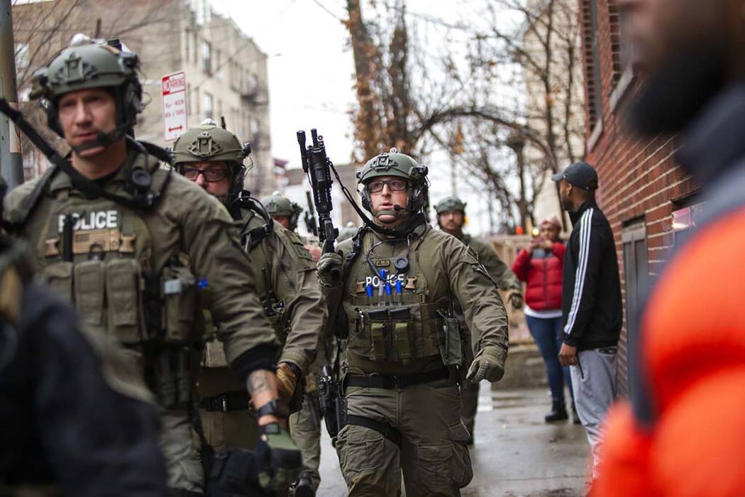 Police officers arrive at the scene following reports of gunfire, Tuesday, Dec. 10, 2019, in Je ...