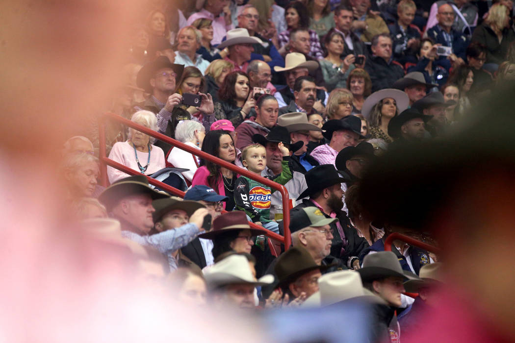 Missi Henderson, 43, of Winfield, Kan., watches the National Finals Rodeo with son Murphy, 4, a ...