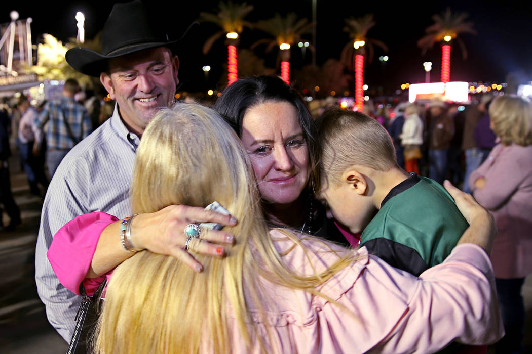 Missi Henderson, 43, of Winfield, Kan., gets a hug from family friend Susan Kanode while holdin ...