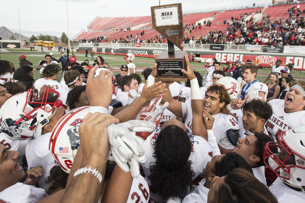 Liberty players celebrate after defeating Centennial 50-7 to win the Class 4A state football ch ...