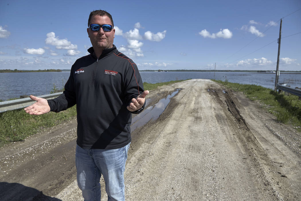 In this May 10, 2019 photo, Brett Adams gestures as he stands where the road to his flooded far ...