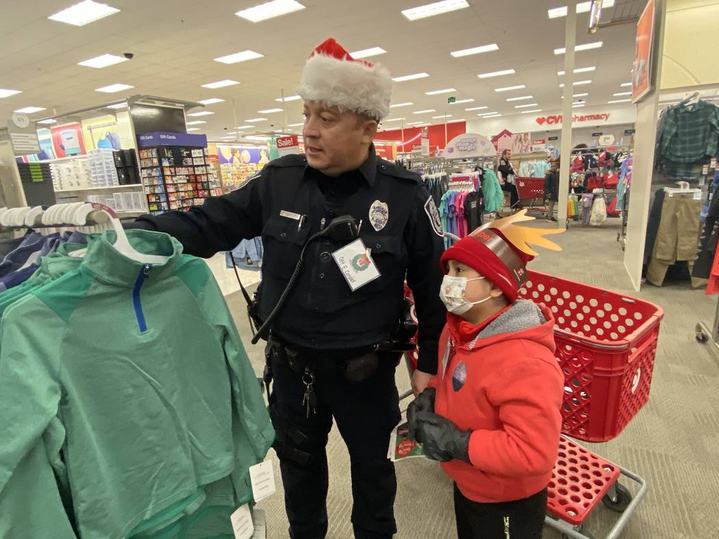 North Las Vegas patrol officer Edwin Corales shows Aiden Pinacruz some clothes he might want to ...