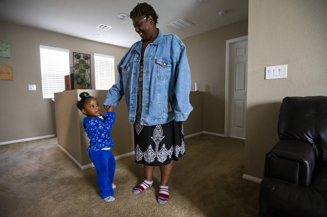 Christine Modica, 3, holds onto the hand of her great-aunt, Lucille McKnight, at their home in ...