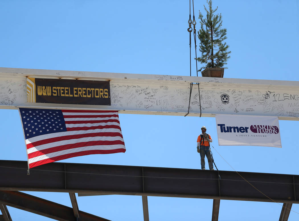 Workers hoist the last high beam on top of the future Las Vegas Convention Center exhibit hall ...