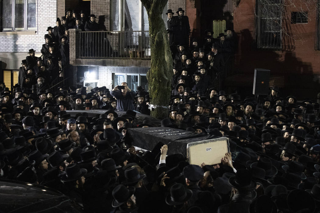 Orthodox Jewish men carry Moshe Deutsch's casket outside a Brooklyn synagogue following his fun ...