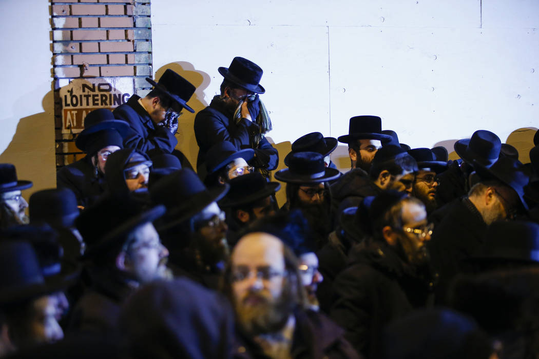 Orthodox Jewish men mourn during the funeral service of Mindel Ferencz who was killed in a kosh ...