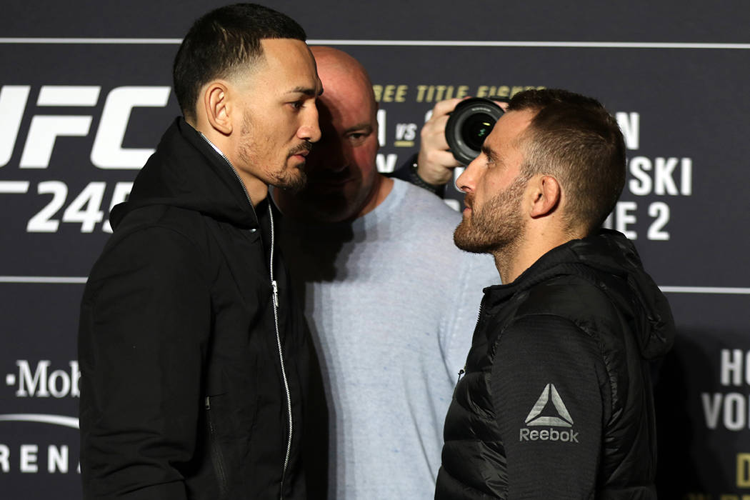 UFC featherweight champion Max Holloway engages in a staredown with his opponent, Alexander Vol ...