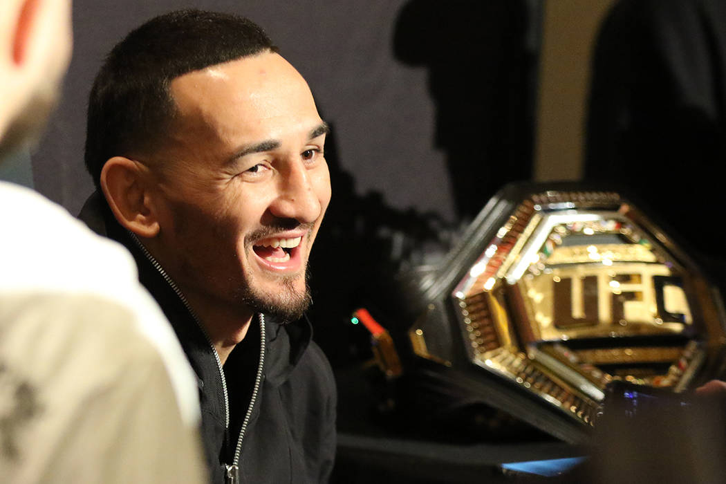 UFC featherweight champion Max Holloway laughs during a scrum with reporters at a UFC 245 media ...