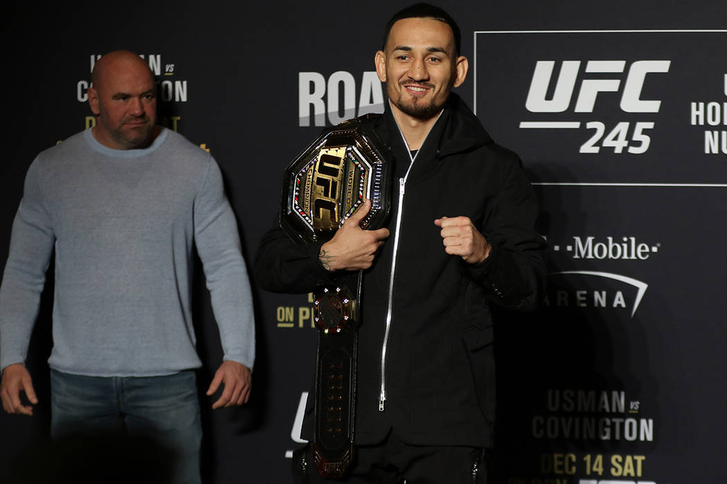 UFC featherweight champion Max Holloway poses during a UFC 245 media event as UFC president Dan ...