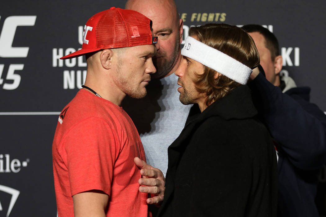 UFC bantamweights Petr Yan and Urijah Faber, right, staredown as UFC president Dana White keeps ...