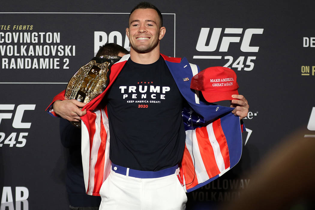 UFC welterweight Colby Covington poses holding his old title belt and Trump hat during a UFC 24 ...