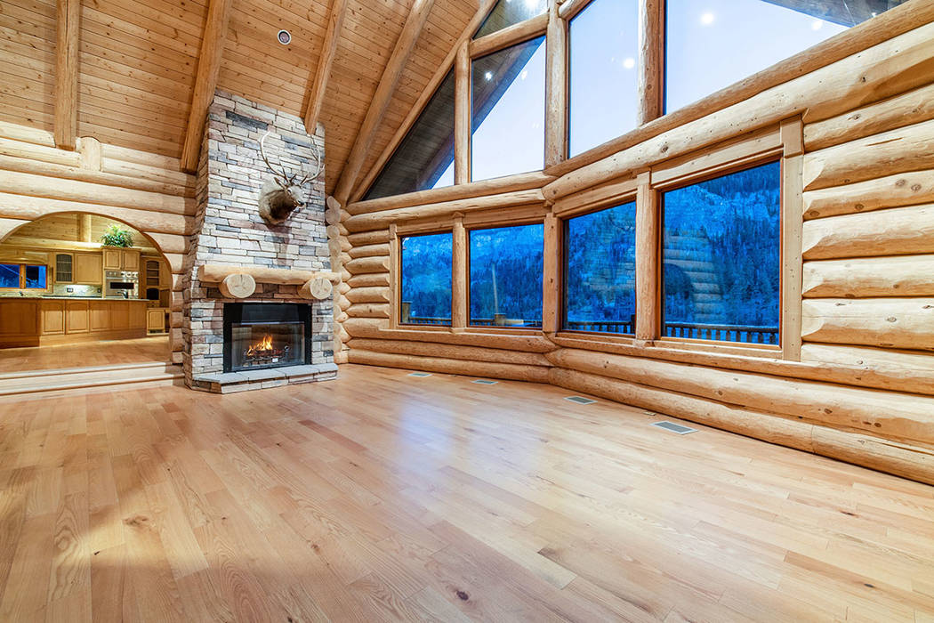 The living room has plenty of windows and a rustic wood-burning fireplace. (Berkshire Hathaway ...
