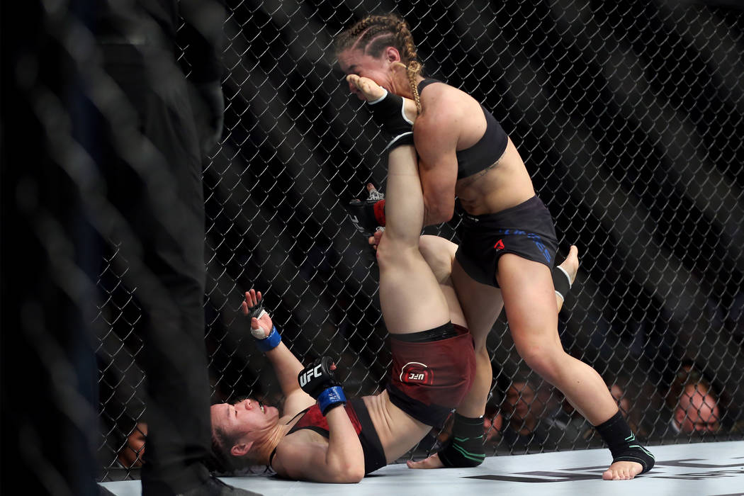 Weili Zhang, left, connects a kick against Tecia Torres in the womenÕs strawweight bout du ...