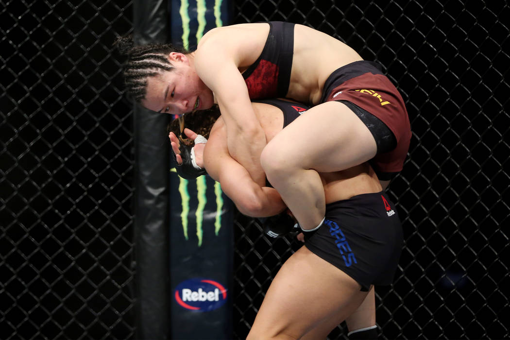 Weili Zhang, top, grabs to Tecia Torres in the womenÕs strawweight bout during UFC 235 at ...