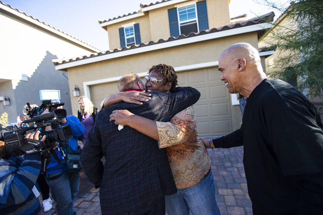 Lucille McKnight, center, hugs Walker Furniture CEO Larry Alterwitz while McKnight's partner, K ...