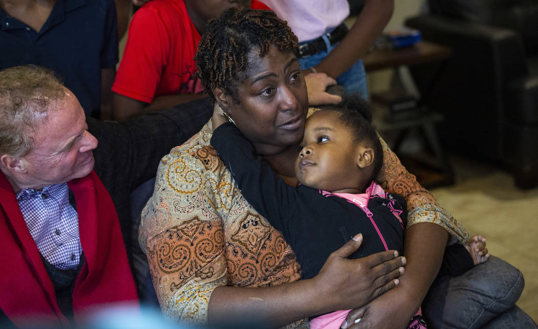 Lucille McKnight holds her great-niece Christine Modica, 3, while talking alongside Walker Furn ...