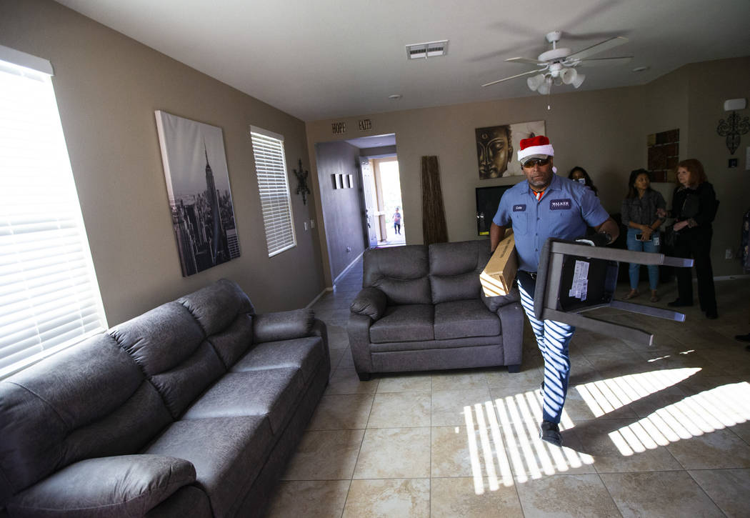 Walker Furniture employee Cole, who declined to give his last name, helps deliver and set up a ...