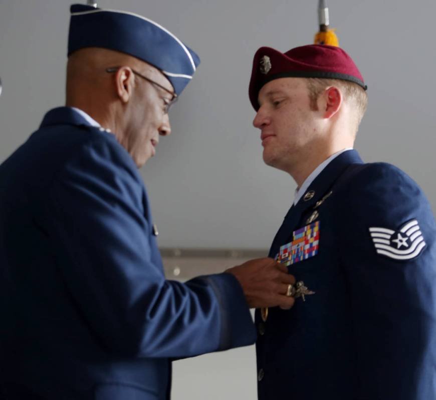 Gen. Charles Brown Jr., left, pins on the Purple Heart Medal onto Technical Sgt. Gavin Fisher d ...