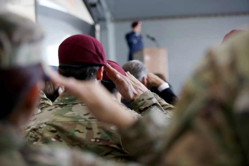 Members of the military salute during a ceremony awarding the Purple Heart and Silver Star Meda ...