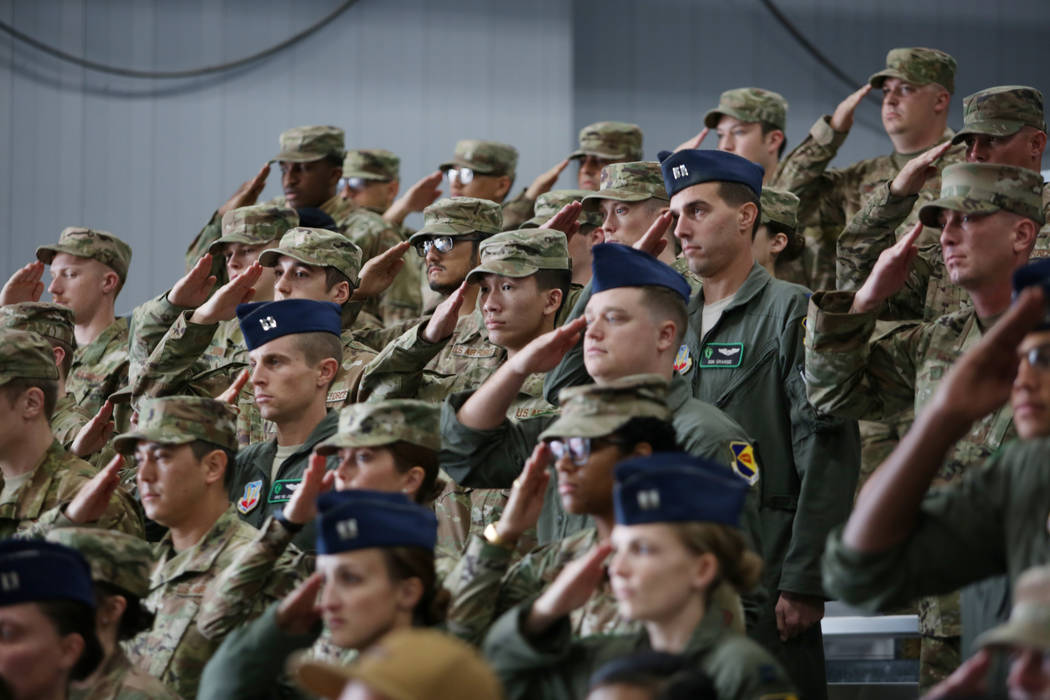 Members of the military salute during a ceremony awarding the Purple Heart and Silver Star Meda ...