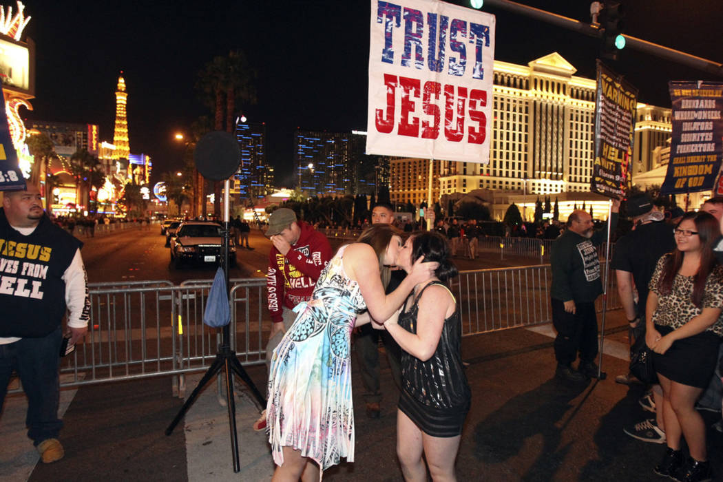 Revelers taunt street preachers with a kiss on the Las Vegas Strip near Flamingo Road on New Ye ...