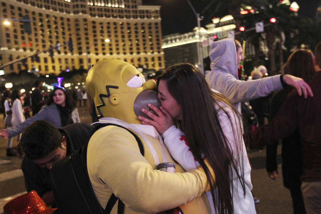 A reveler steals a kiss from Homer Simpson during the New Year's Eve celebration on the Las Veg ...