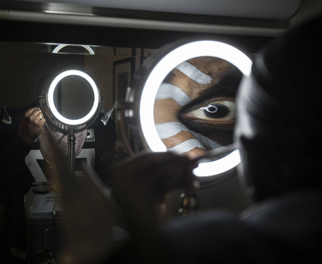 Raiders super fan Wayne Mabry, known as "Violator," applies makeup in his hotel room ...