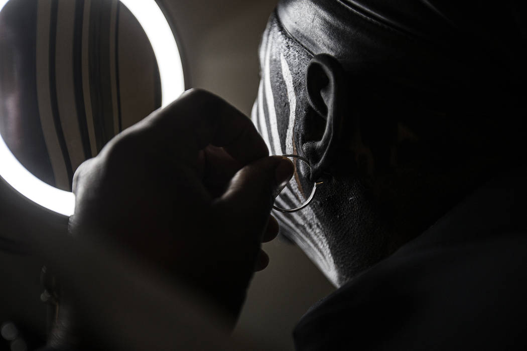 Raiders super fan Wayne Mabry, known as "Violator," puts his trademark earring in at ...