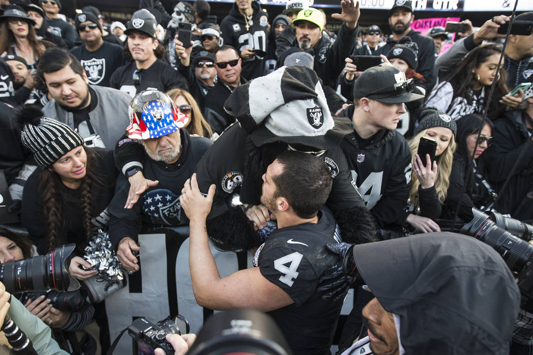 Oakland Raiders quarterback Derek Carr (4) hugs fans in the "Black Hole" after Oaklan ...